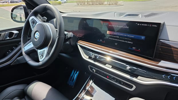 Ottawa, ON Canada - 04.22.2023: Interior View of a Luxury BMW X5 Car s Dashboard with a Large Infotainment Screen Displaying Car Settings.