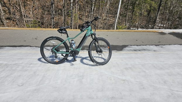 Ottawa, ON Canada - 04.15.2024: Adventure Awaits Mountain iGo electric Bike Ready for a Ride on a Snowy Path, Outdoor Exploration.
