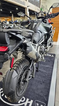 Ottawa, ON Canada - 04.22.2023: Powerful Adventure Triumph Motorcycle with Rugged Tire and Sleek Exhaust System in Showroom.