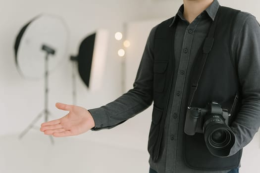 AI generated A professional photographer stands at the frame's edge gesturing toward a fully equipped photo studio with lighting and backdrops. The creative workspace conveys visual storytelling