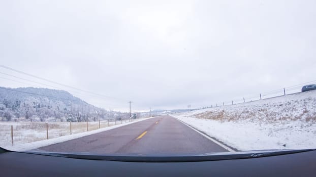 The open highway invites a peaceful drive, with snow-clad pines lining I-25 as the journey continues from Denver towards Colorado Springs on a snowy day.