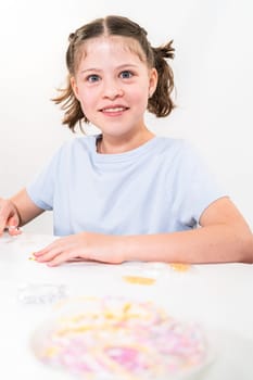 Little girl enjoys crafting colorful bracelets with vibrant clay beads set.