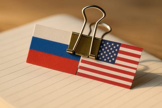 Close-Up of Russian and American Paper Flags Clipped Together on Notebook Page