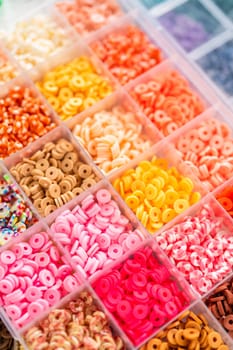 Assorted clay bead boxes neatly arranged on a white table, awaiting a creative kids' craft project.