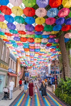 Hanging multicolored bright colorful umbrellas decorating festive street on Magic City Park in Tashkent. Tashkent, Uzbekistan - June 15, 2024