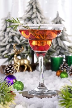Christmas Manhattan cocktail. Served in a glass with a decorated rim, cranberries, rosemary. Cocktail filled with festive Christmas flavors