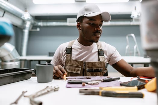 A focused individual organizes various tools on a table in a contemporary workshop.
