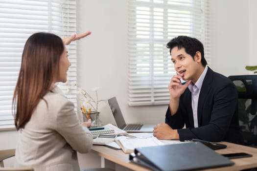 A woman enthusiastically explaining financial concepts to a man, fostering collaboration in a contemporary office setting.