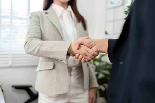 Two professionals engaging in a handshake, symbolizing agreement and collaboration in a financial context.