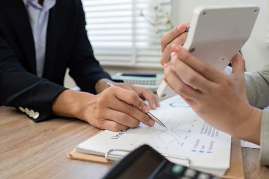 Two business professionals engaged in a financial consultation, analyzing charts and discussing strategies at a modern office desk.