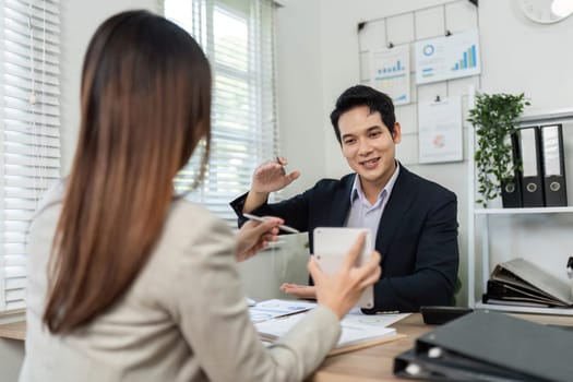 A man and woman in a professional setting discussing financial strategies, emphasizing collaboration and teamwork.