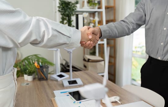 A close-up view of two colleagues shaking hands, emphasizing their partnership and commitment to ESG values in business.