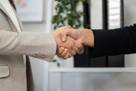 Two business professionals shake hands, symbolizing a successful financial agreement and partnership.