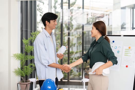 Engineers shake hands after discussing sustainable project plans, emphasizing collaboration and environmental responsibility.