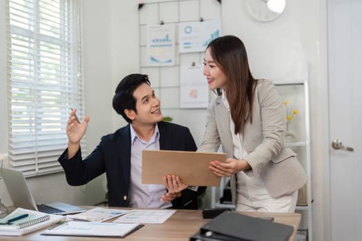 Two business professionals enthusiastically discuss financial strategies and share insights in a modern office setting.
