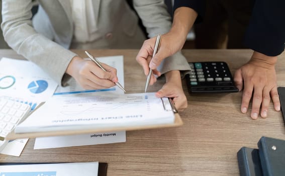 Two business professionals engaged in a detailed review of financial documents, collaborating on strategies in a modern office.