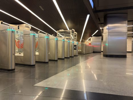 Modern turnstile gate system with illuminated access indicators at metro station, emphasizing advanced public transport infrastructure and automated fare control technology