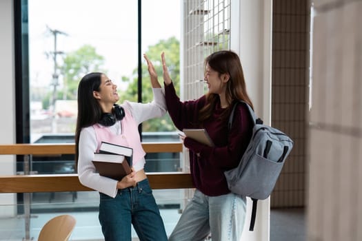 Two students celebrate their collaborative efforts with a high-five, showcasing camaraderie and the joy of achievement in an encouraging school setting.