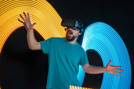 man with virtual reality glasses on an abstract background with neon lights. High quality photo