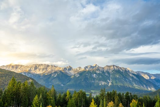 Stunning mountain landscape with lush forests and a dramatic, captivating sky.