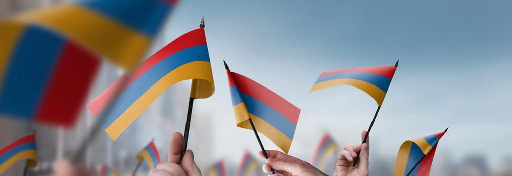 Armenia flags in their hands on a blurred urban background. The photo illustration was created without the use of artificial intelligence, only using Photoshop.