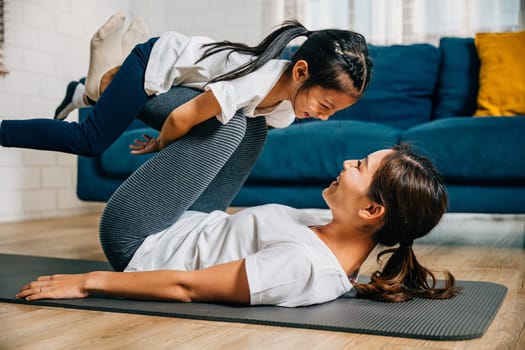 In a harmonious family fitness session a mother and her child playfully pretend to 'fly' like airplanes while practicing Pilates and yoga enhancing their bond trust and happiness.