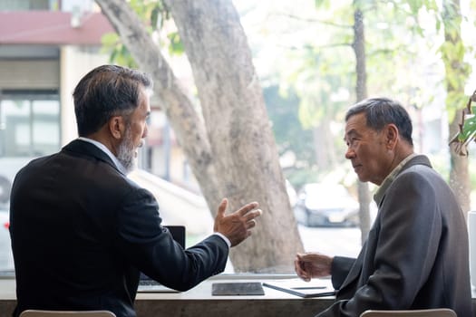 Two senior men engage in a thoughtful conversation, showcasing the value of experience and mentorship in business.