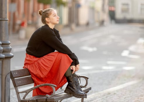 Young Girl Sitting On Bench In The City