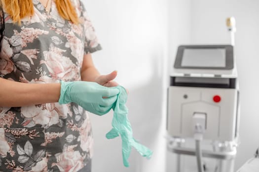 Laser Hair Removal Expert Putting On Gloves With An Epilation Device In The Background