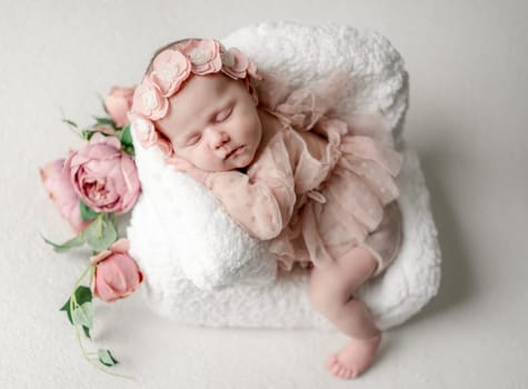Newborn Baby Girl Sleeping In Tiny Chair During Studio Photoshoot