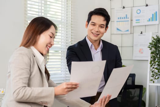 Two business partners reviewing financial documents together, showcasing collaboration and communication in financial planning.
