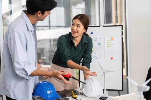 Engineers engaged in a hands-on renewable energy project, emphasizing collaboration and innovation in a bright office space.