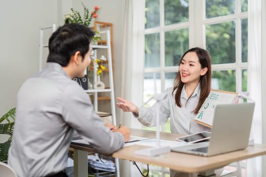 A businesswoman explains ESG concepts to a client during a meeting, highlighting sustainability and corporate responsibility.