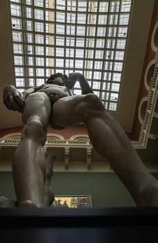 London, UK - May 07, 2025 - Looking up of A magnificent plaster cast of Michelangelo's David sculpture, uses metal rods to support the structure to mount the left and right arms to the torso Displayed in The V&A (Victoria and Albert Museum) in London. use it as your Wallpaper, Poster and Space for text, Selective focus.