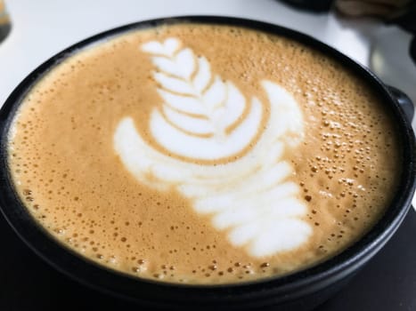 Close up of a latte art design featuring a delicate leaf pattern in a cusco coffee shop, showcasing the barista's skill