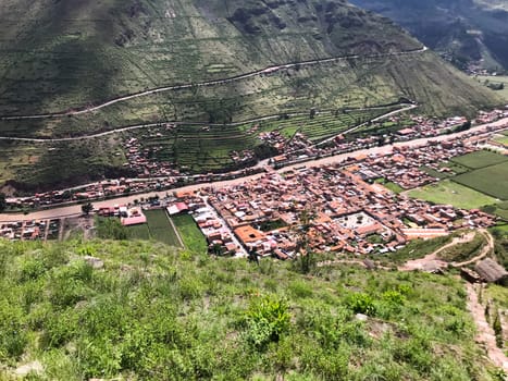 Lush green valley and winding road leading to the town of calca, offering a picturesque view of the peruvian landscape
