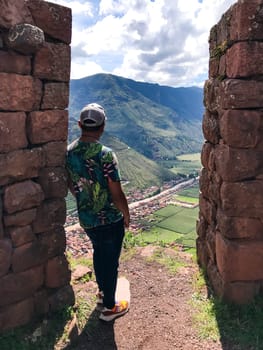 Tourist observing the sacred valley of the incas from the ancient ruins of puka pukara near cusco, peru