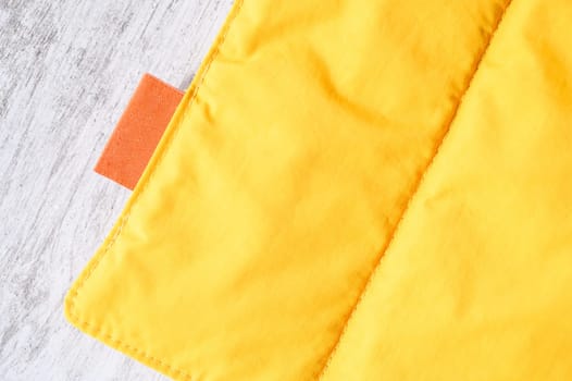 Close up of yellow pet friendly waterproof and windproof breathable fabric with orange label, ideal for outdoor activities