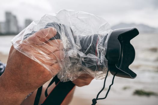 professional camera in a waterproof case that protects against rain and splashes in nature on a rainy day