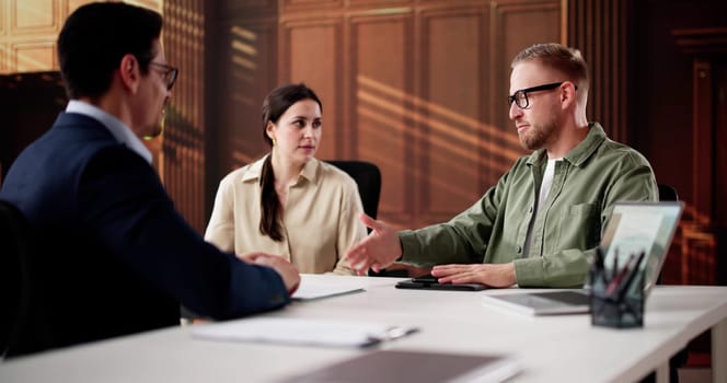 Family Divorce Lawyer Consulting Young Couple In Court For Financial Advice.