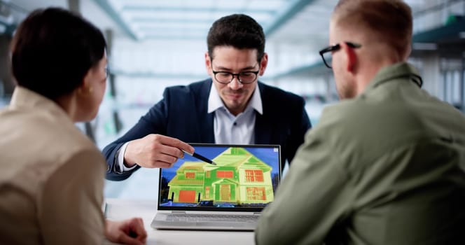Hispanic Couple Consulting Thermal Imaging For Home Energy Efficiency Inspection.