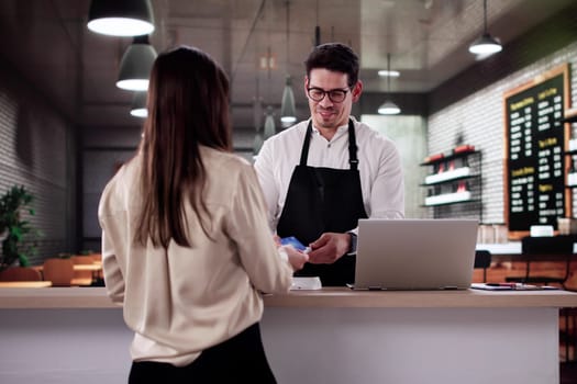 Smiling Customer Pays Barista With Credit Card In Happy Cafe