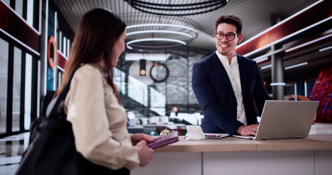 Professional Concierge Assisting Woman With Check-In At Hotel Reception.