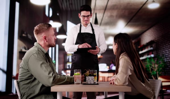 Romantic Couple Celebrates Anniversary With Elegant Waiter Taking Dinner Menu.