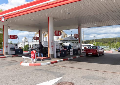05.05.2025 - Minsk, Belarus. Petrol station in the city with orthodox church on the background