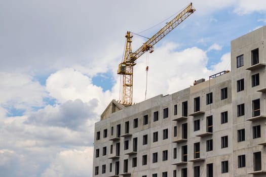 Industrial crane next to the building under construction