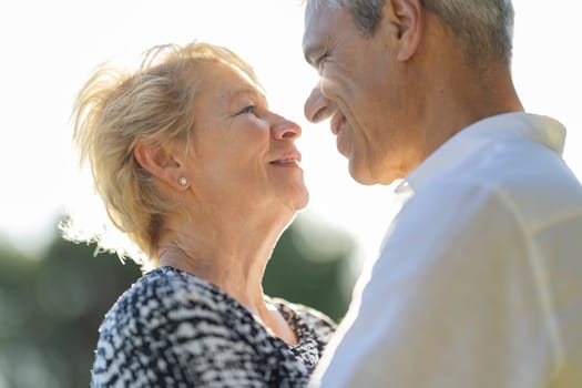 Elderly couple enjoying a romantic moment together in the sunlight