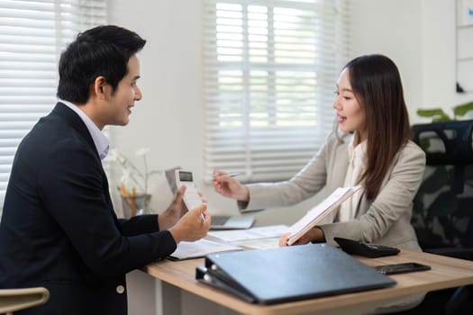 A financial advisor engages with a client in a modern office setting, reviewing documents and discussing investment options for financial empowerment.