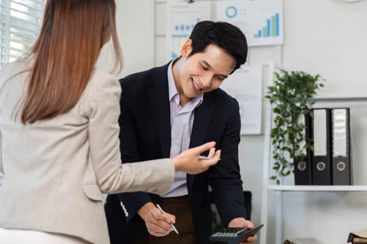 Two business partners discussing financial figures, highlighting teamwork and collaboration in financial decision-making.