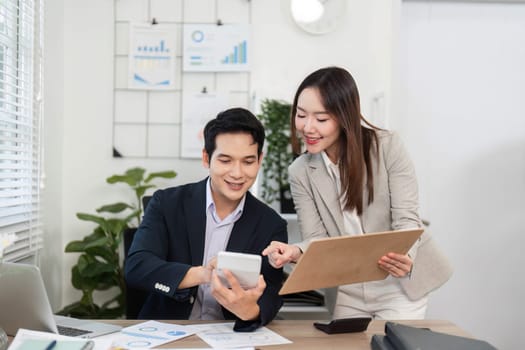 Two colleagues share insights while analyzing financial data on a tablet, highlighting teamwork and collaboration in a bright office.